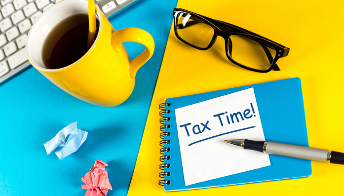 Tax time image with coffee, glasses and note pad